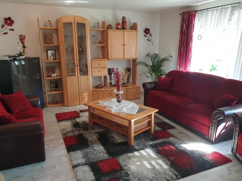 uma sala de estar com um sofá vermelho e uma mesa de centro em Ana‘s Ferienwohnung em Furth im Wald