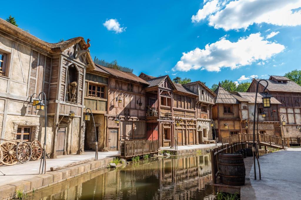 un centro storico con acqua di fronte agli edifici di Les Quais de Lutèce a Plailly