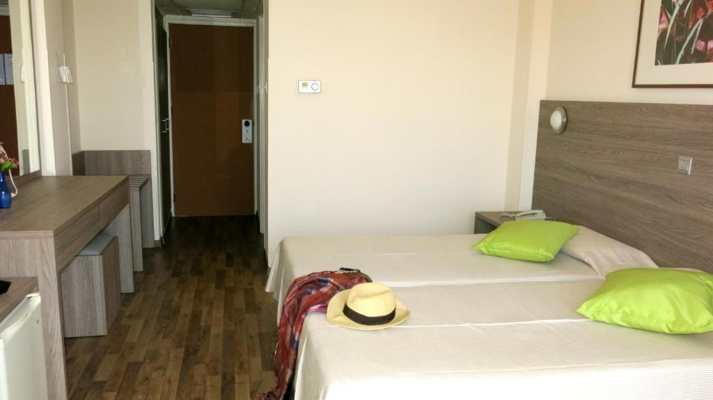 a hotel room with two beds and a hat on the bed at Marina Hotel in Ayia Napa