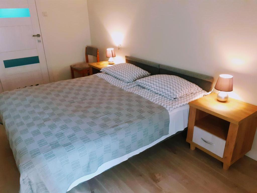 a small bedroom with a bed and two night stands at Pokoje Gościnne OAZA in Sztutowo