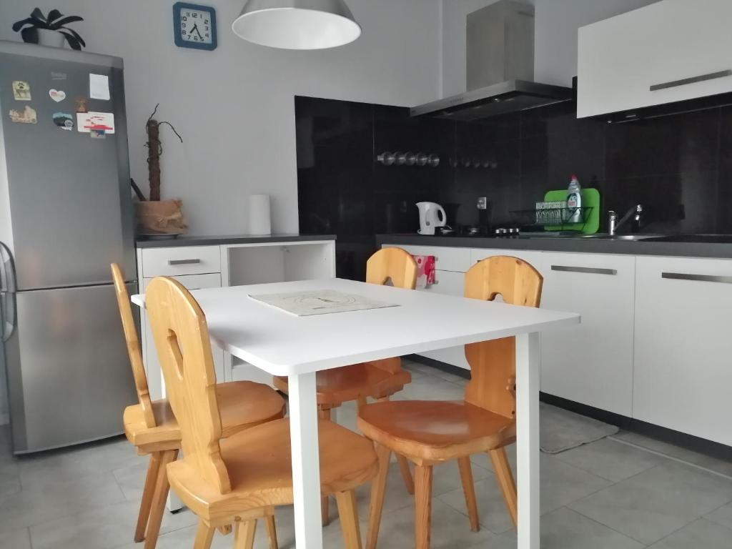 a kitchen with a white table and four chairs at Mieszkanie u Zofii - Krościenko n.D in Krościenko