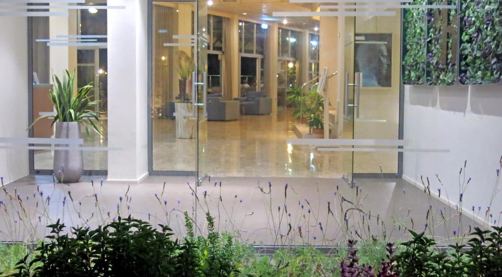 a lobby of a building with glass doors and potted plants at Marina Hotel in Ayia Napa