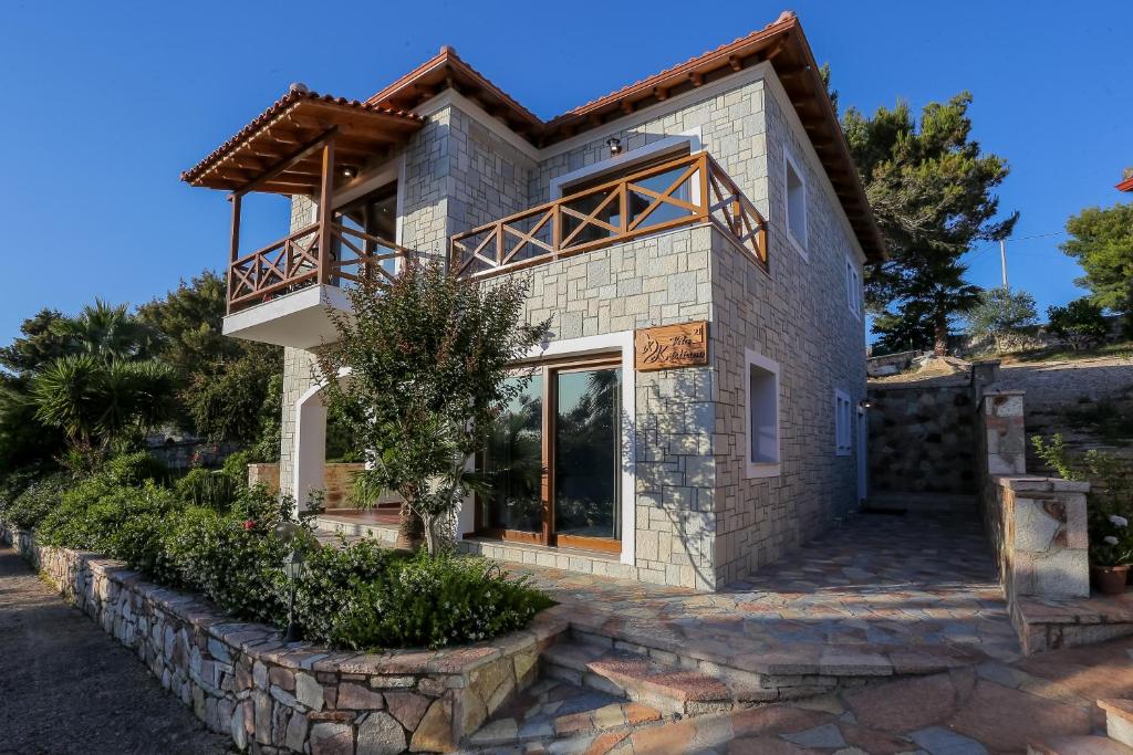 a house with a balcony on a stone wall at Villa Kristiano 21 in Sarandë