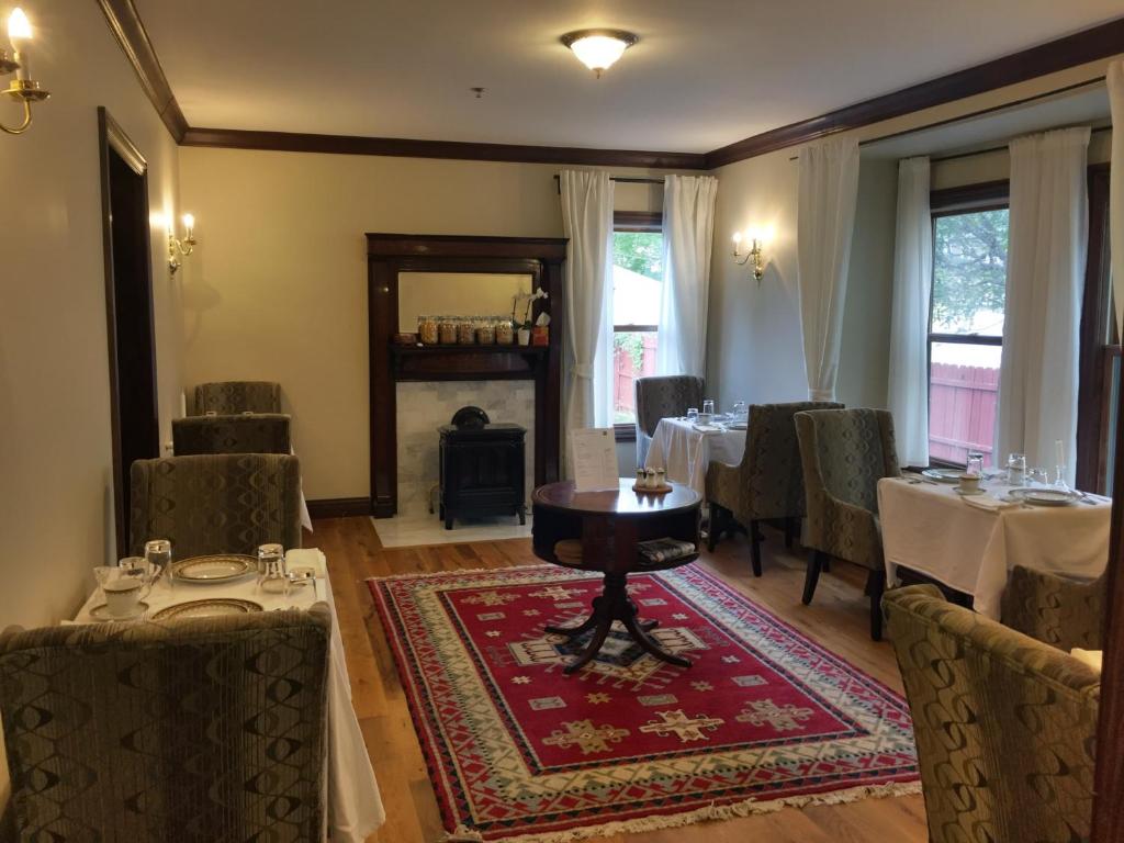 ein Esszimmer mit Tischen, Stühlen und einem Kamin in der Unterkunft Dartmouth House in Rochester