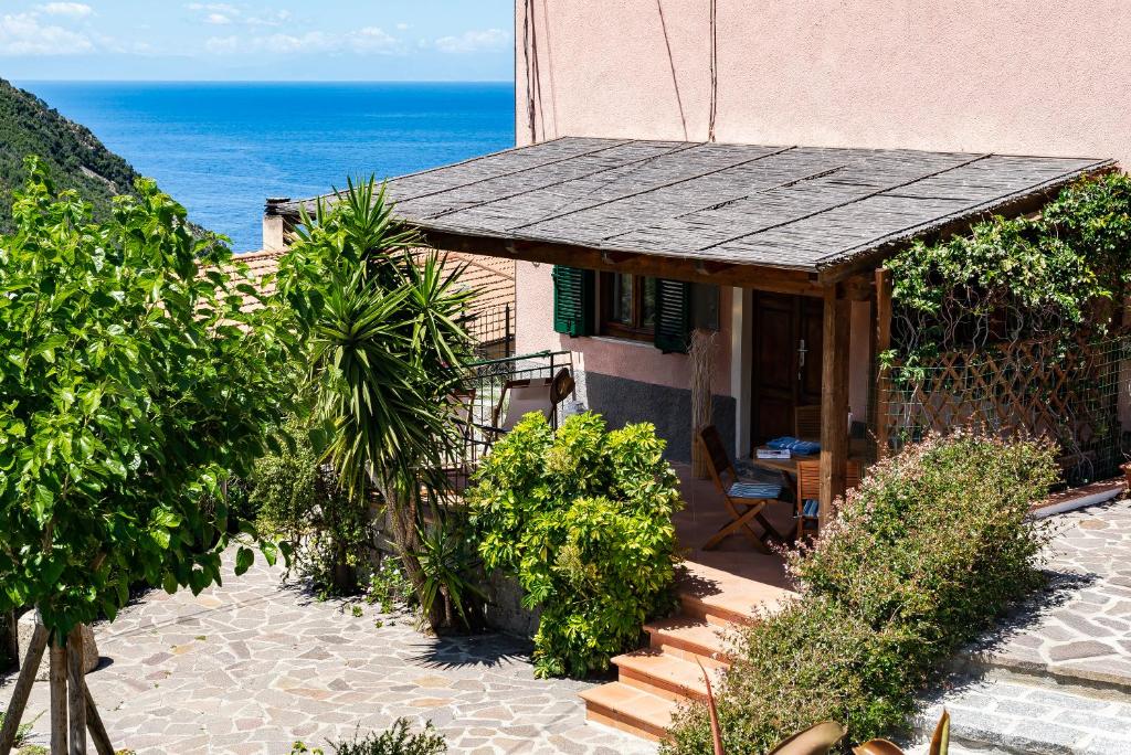 a house with a porch with the ocean in the background at Casa Gelso in Marciana