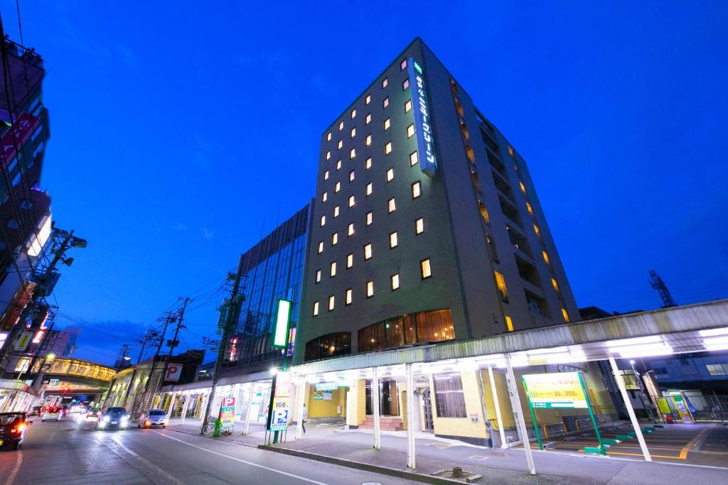 un edificio alto en una calle de la ciudad por la noche en Hotel New Green, en Nagaoka