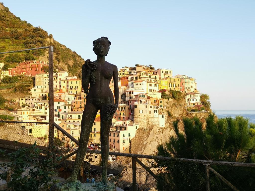 a statue of a woman in front of a city at Sentieri Sul Mare in Manarola