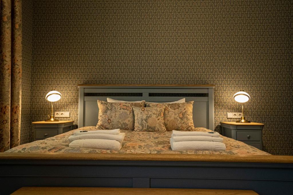 una camera da letto con un grande letto con due lampade su due tavoli di Roze Boutique Apartments a Liepāja