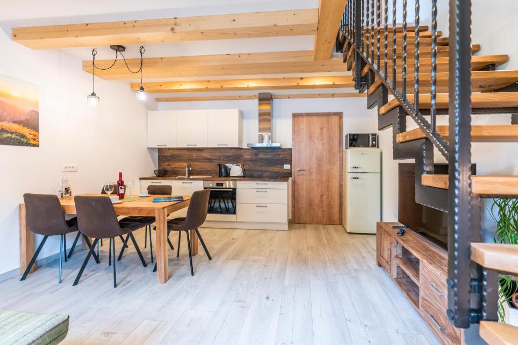 a kitchen and dining room with a table and chairs at Apartmaji MM in Bohinj