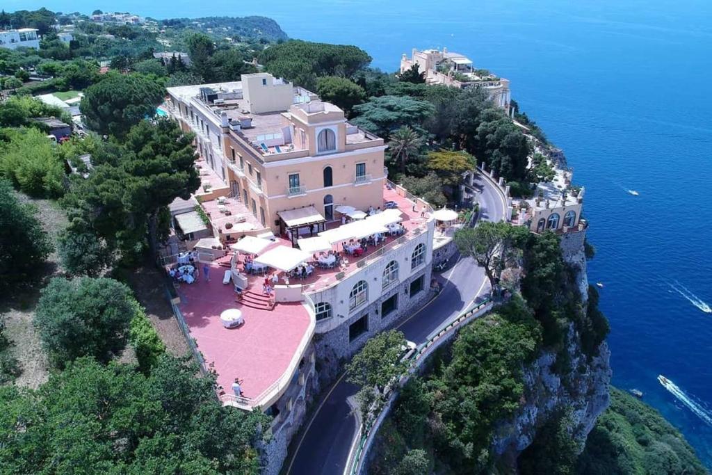 a building on a cliff next to the water at Hotel San Michele in Anacapri