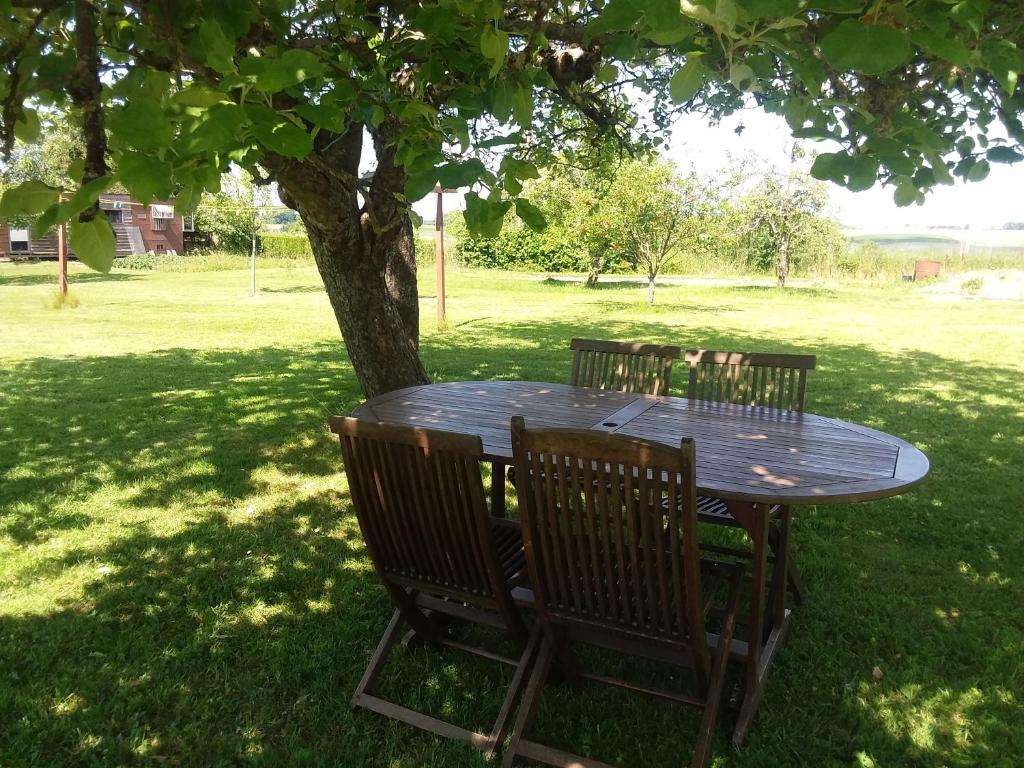 una mesa de picnic bajo un árbol en un parque en Aux trois petites notes, en La Sabotterie