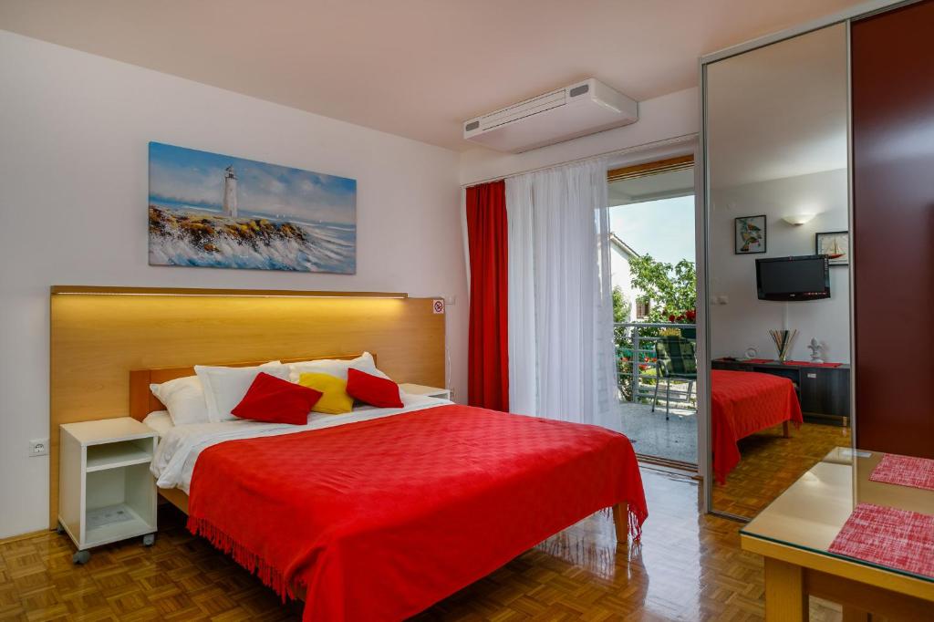 pokój hotelowy z łóżkiem z czerwonym kocem w obiekcie Studios Nada w Krku