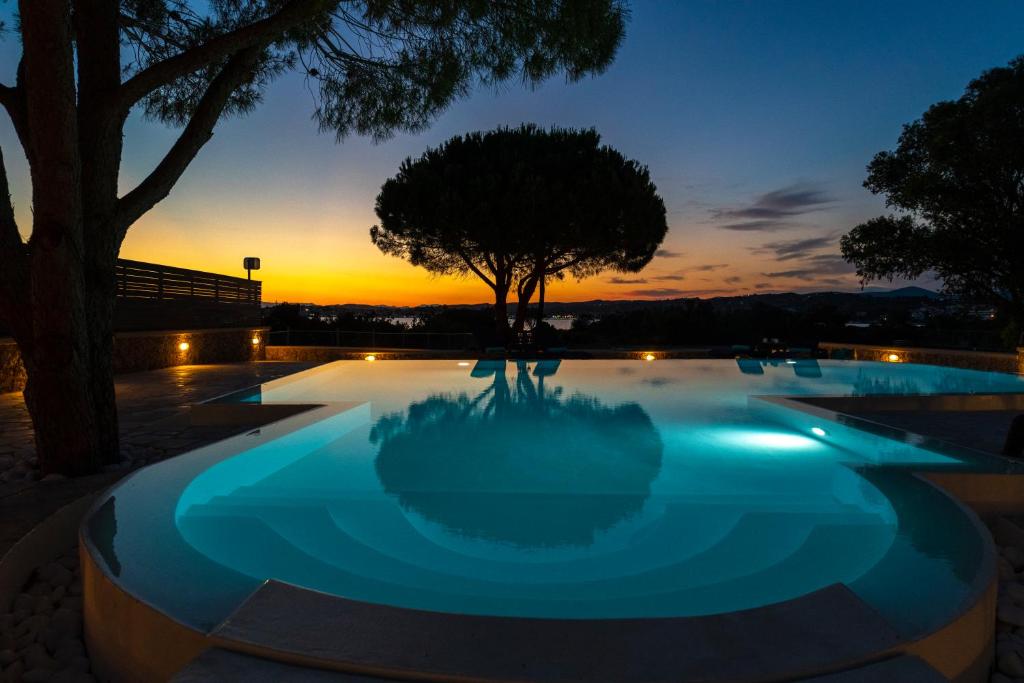 una piscina con puesta de sol en el fondo en Villa Amethyst, en Porto Heli