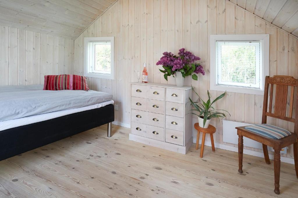 ein Schlafzimmer mit einem Bett, einer Kommode und einem Stuhl in der Unterkunft Brørup Kjærsgaard, Hygge, ro, natur og landliv in Skanderborg