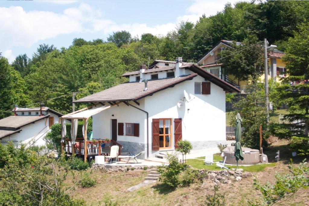 une petite maison blanche sur une colline avec des arbres dans l'établissement La casetta di Kamma & Niels a Montenotte, à Montenotte Inferiore
