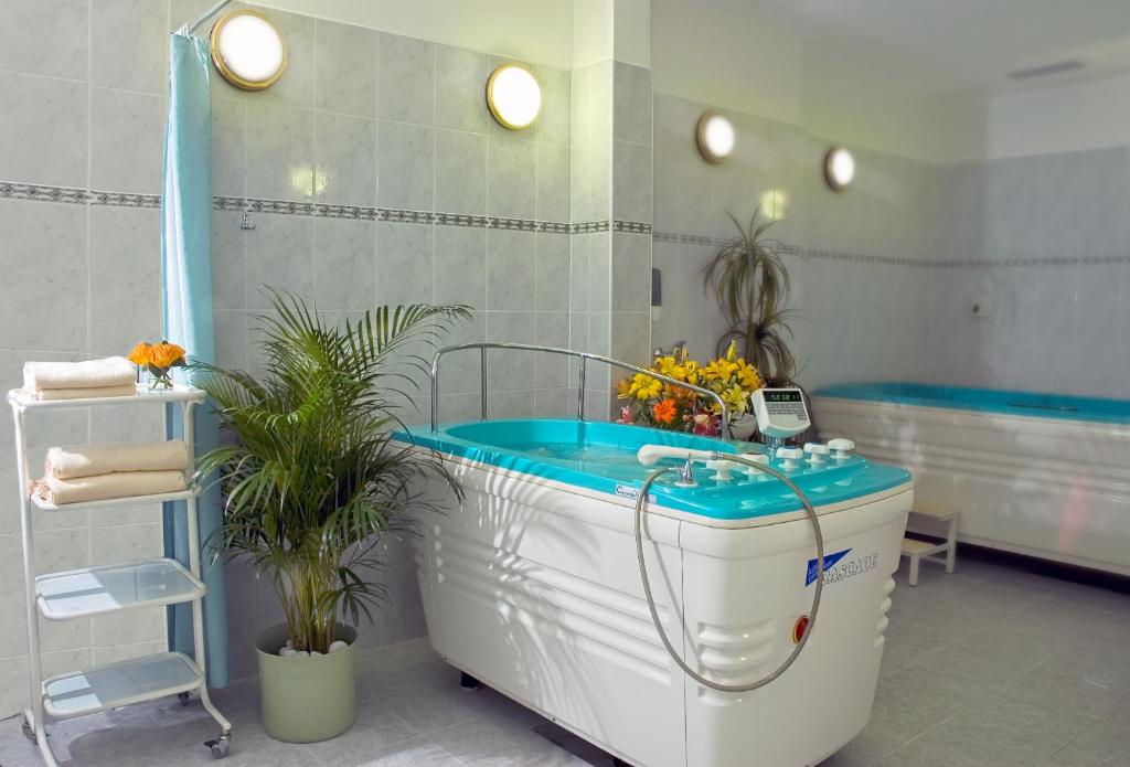 a bath tub in a bathroom with a blue tub at Interhotel Central in Karlovy Vary