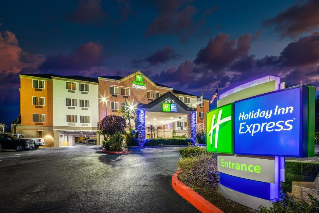 a hotel with a holiday inn express sign in a parking lot at Holiday Inn Express Castro Valley in Castro Valley