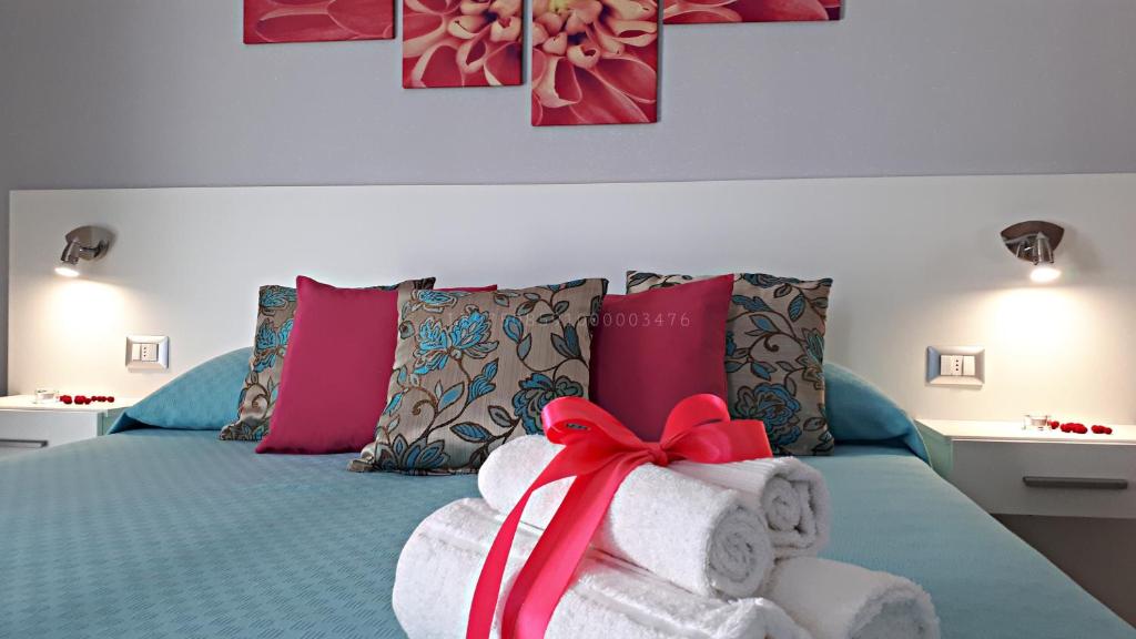 a bed with towels and a bow on it at L’Angolo Chiaro in Taviano