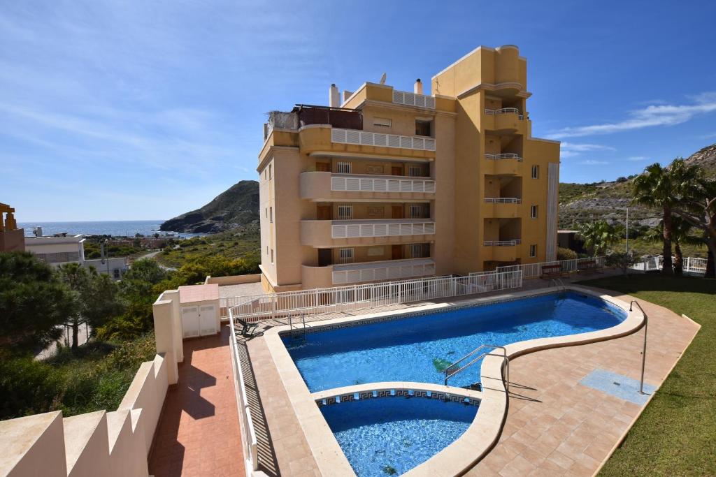 a resort with a swimming pool and a building at Cala Reona Apartamentos in Cabo de Palos