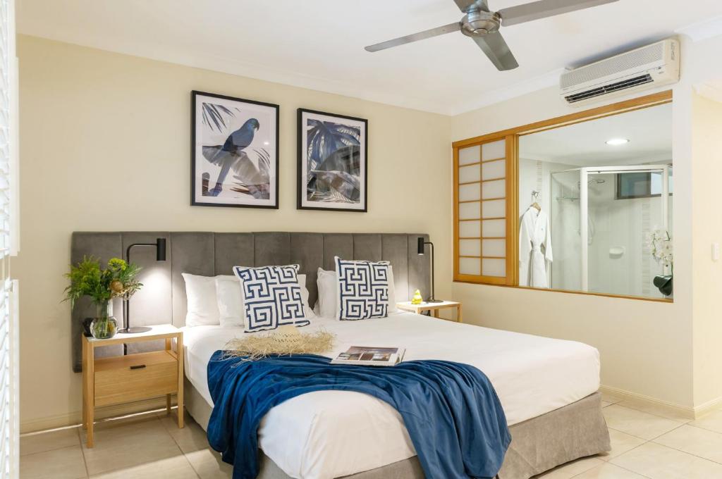 ein Schlafzimmer mit einem großen Bett und einem Spiegel in der Unterkunft Shantara Resort Port Douglas - Adults Only Retreat in Port Douglas
