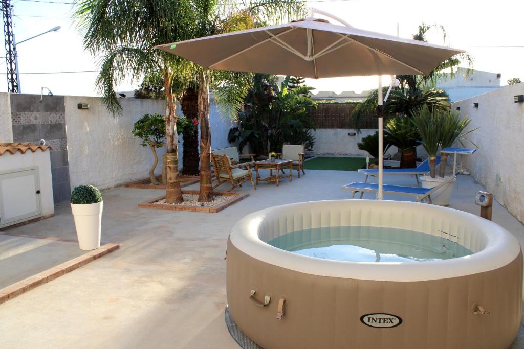 a hot tub with an umbrella on a patio at Terre di Sicilia in Marsala