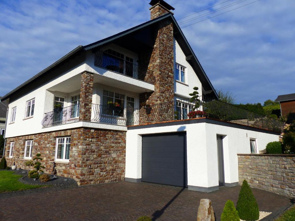 a white house with a black roof and a garage at Ferien Apartment Melcher in Zeltingen-Rachtig