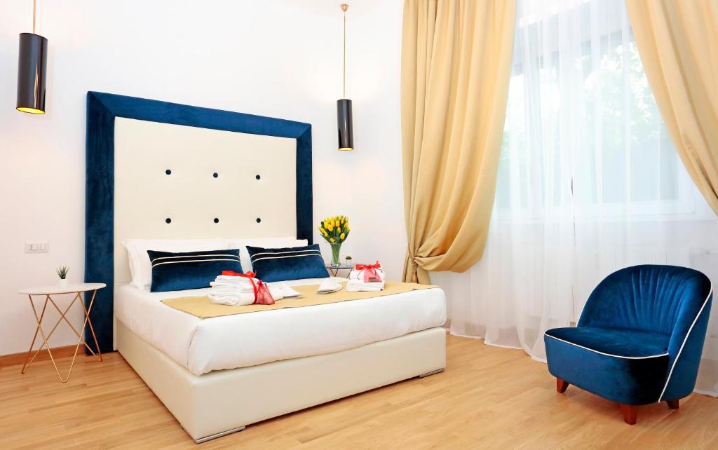 1 dormitorio con 1 cama y 1 silla azul en HeMi Suites en Milán