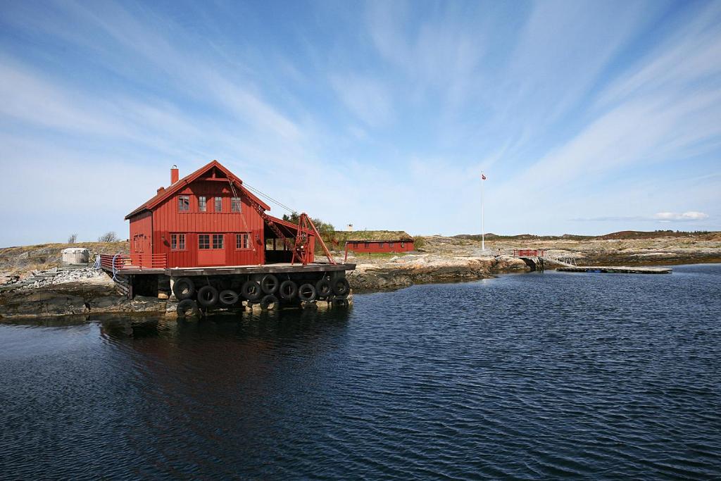 una casa roja en un muelle en el agua en Korsholmen - by Classic Norway Hotels, en Karvåg