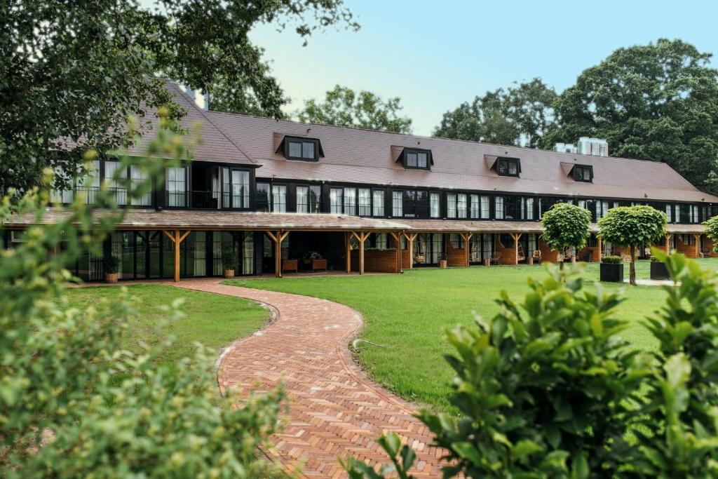 an exterior view of a large building with a lawn at Van der Valk Hotel Apeldoorn - de Cantharel in Apeldoorn