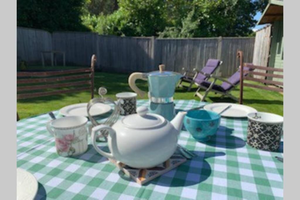 a table with a tea set on a checkered table cloth at Rose Cottage in Lymington