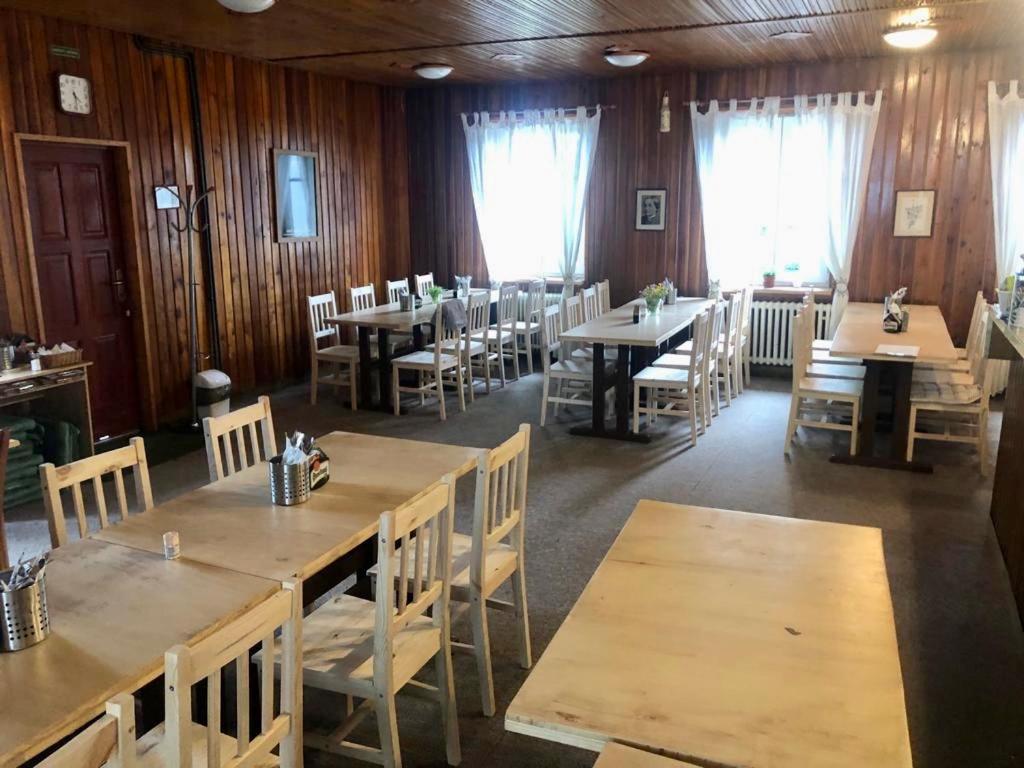 a restaurant with wooden walls and tables and chairs at Turistická Chata Pláně in Český Dub