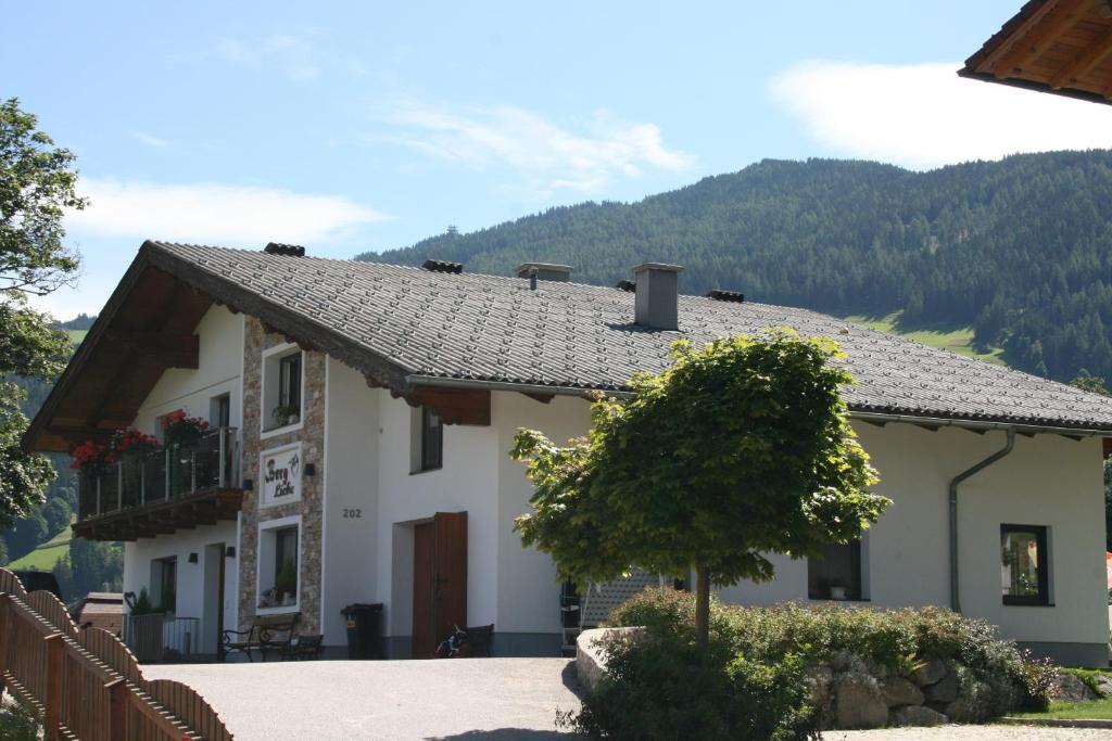 una casa blanca con una montaña en el fondo en Haus Bergliebe, en Schladming