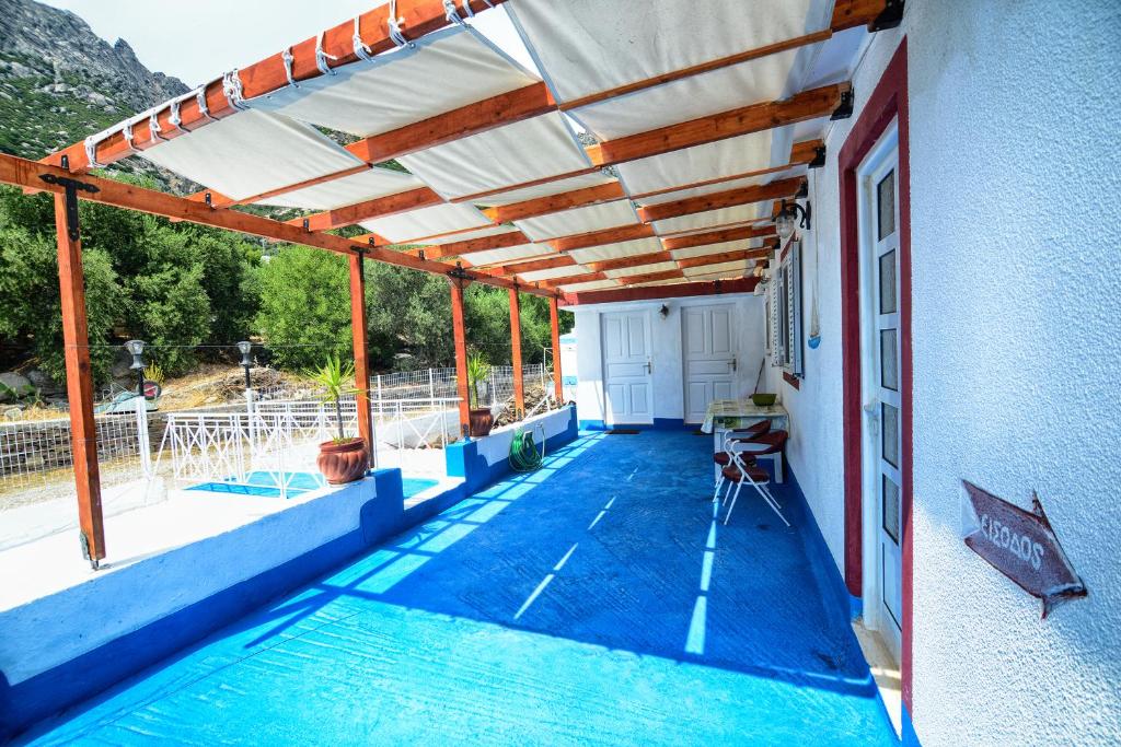 a pergola over a swimming pool on a house at Ikaria Studios in Manganítis