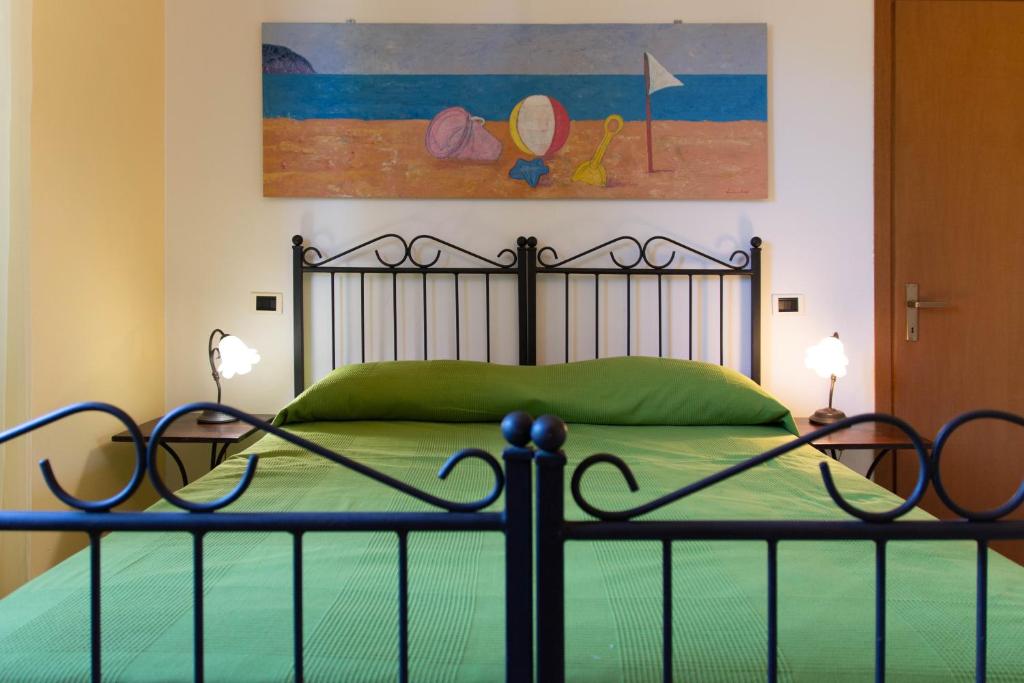 een slaapkamer met een groen bed met 2 lampen bij Agriturismo OlivoMare in Piombino