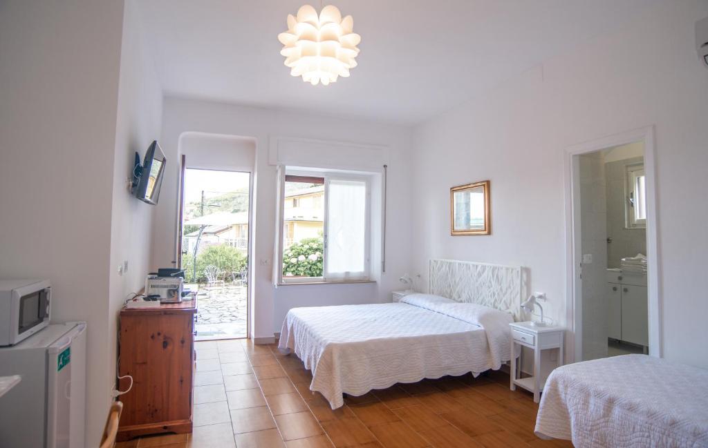 a white bedroom with two beds and a window at Villa Mori in Levanto