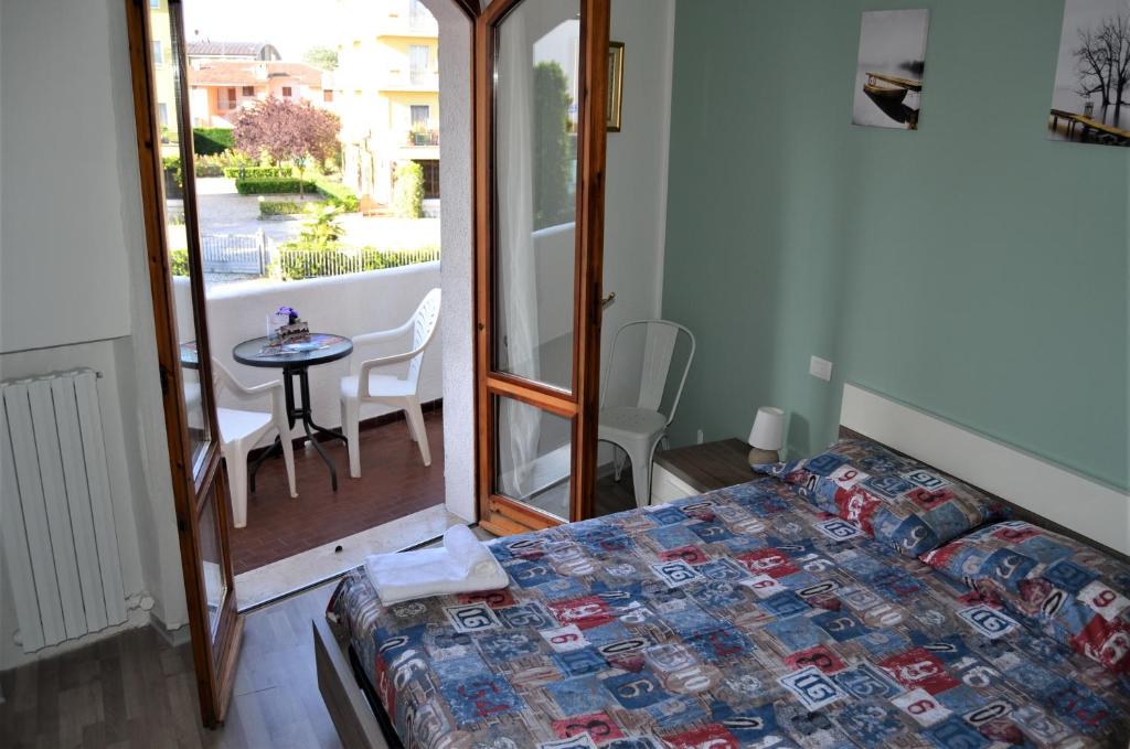 sypialnia z łóżkiem i stołem oraz balkonem w obiekcie Mattia's House on Garda Lake w mieście Peschiera del Garda