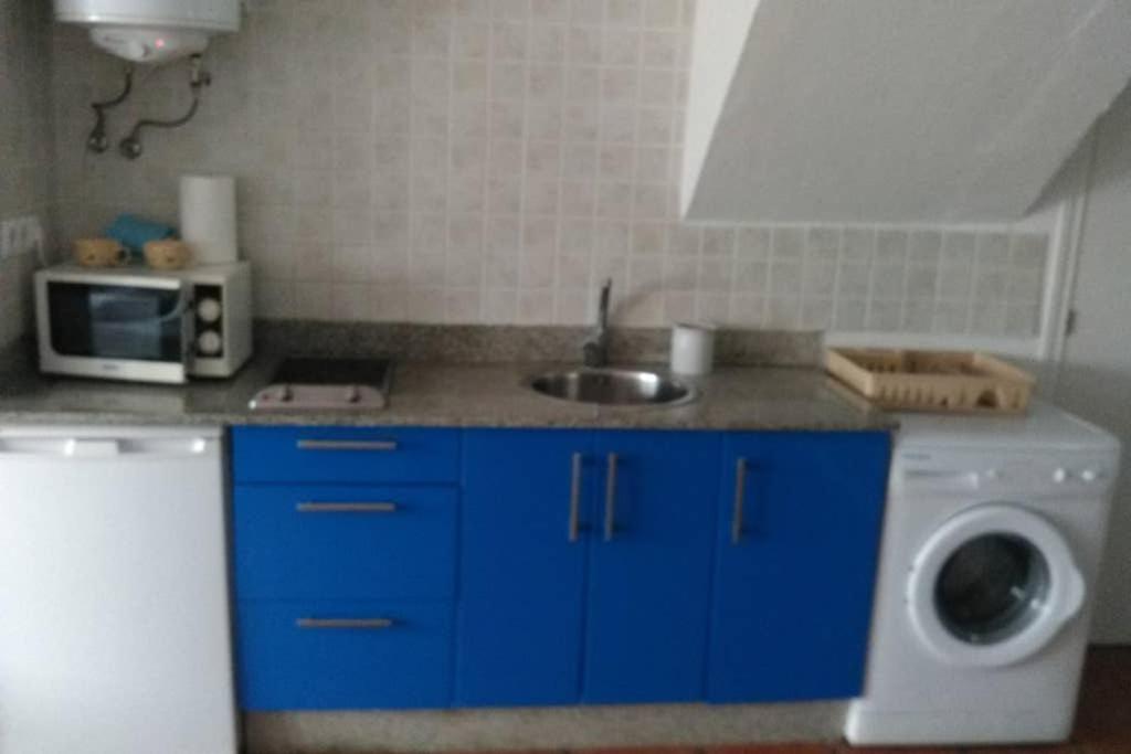 een keuken met een spoelbak en een wasmachine bij Apartamento Soleado in Tarifa