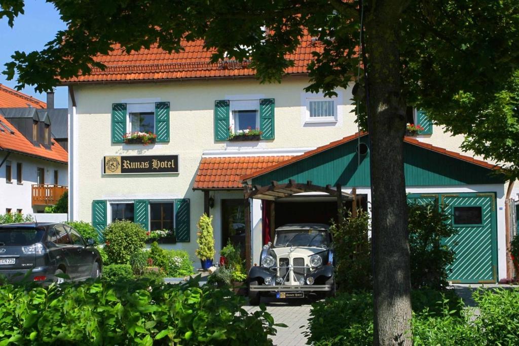 um carro velho estacionado em frente a um edifício em Runa´s Hotel em Hallbergmoos