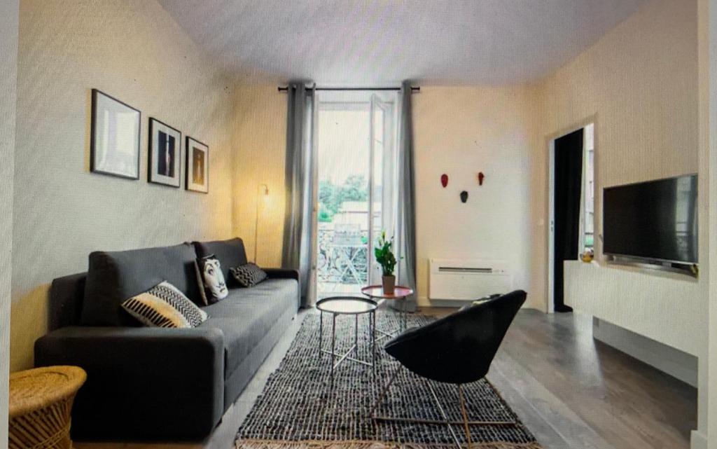 un salon avec un canapé et une télévision dans l'établissement T2 neuf Clim Balcon Garibaldi Acropolis, à Nice