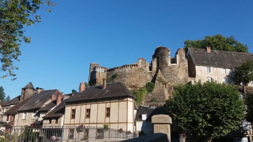 un viejo castillo se encuentra en la cima de una ciudad en La Ruche Chambres d'hôtes, en Ségur-le-Château