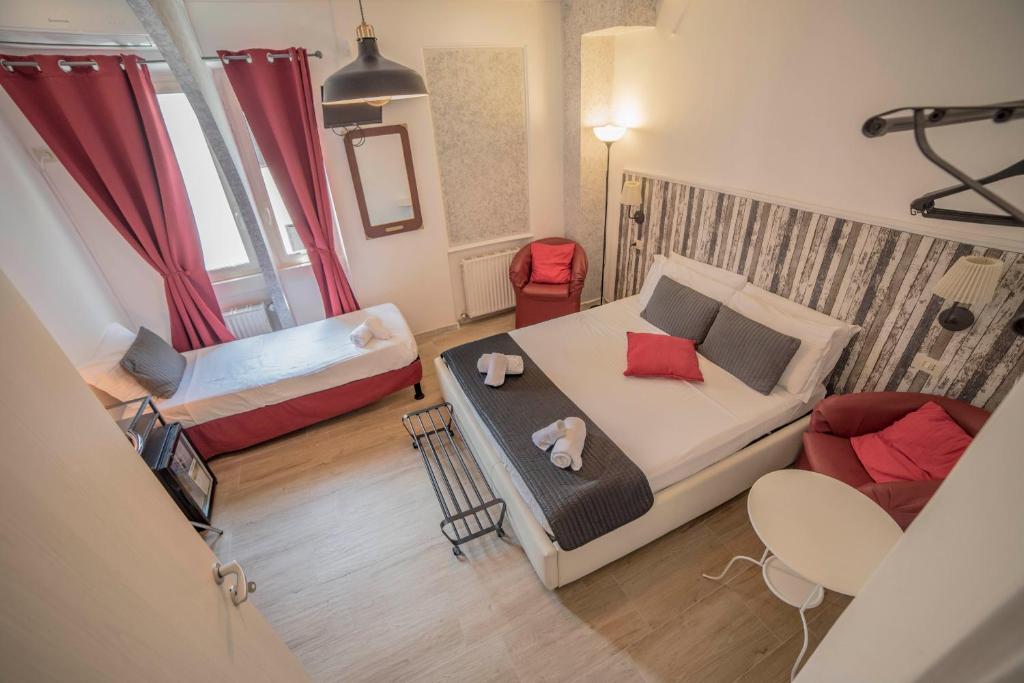 um pequeno quarto com uma cama e um sofá em Galleria Frascati Rooms and Apartment em Frascati