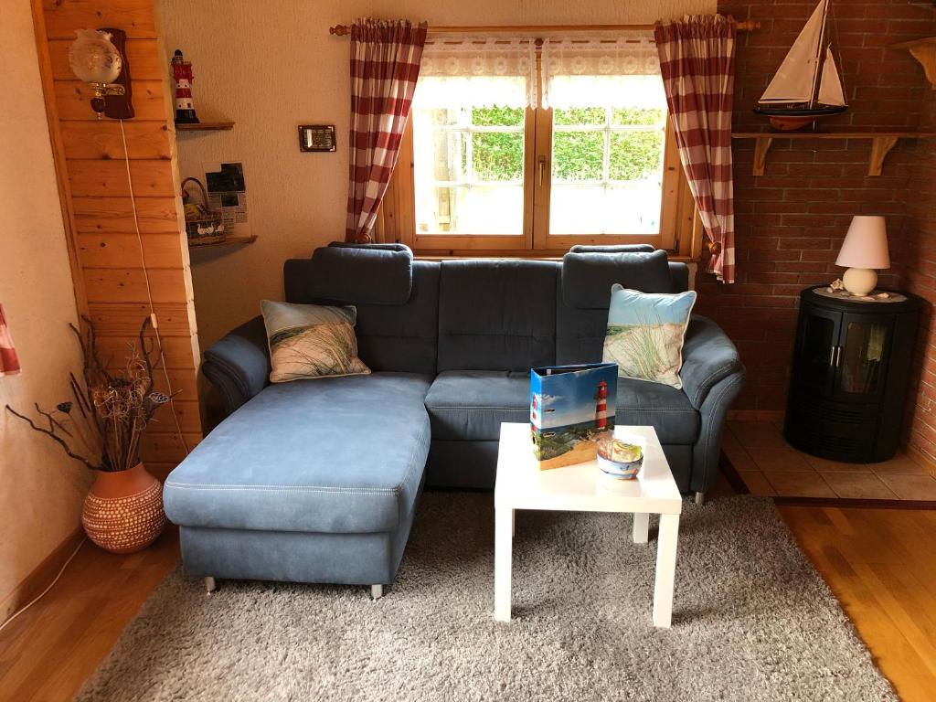 a living room with a blue couch and a table at Ferienhaus Möwenherz in Pruchten