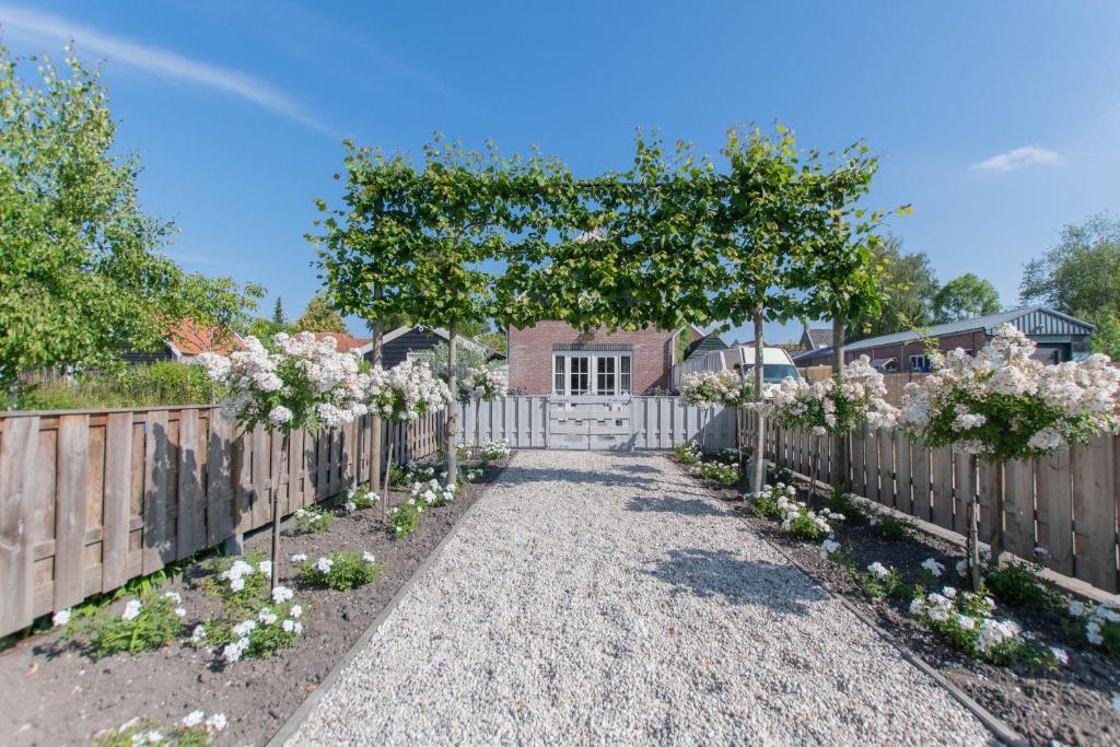 a garden with white flowers in front of a fence at Vakantiewoning t Uusje Wemeldinge in Wemeldinge