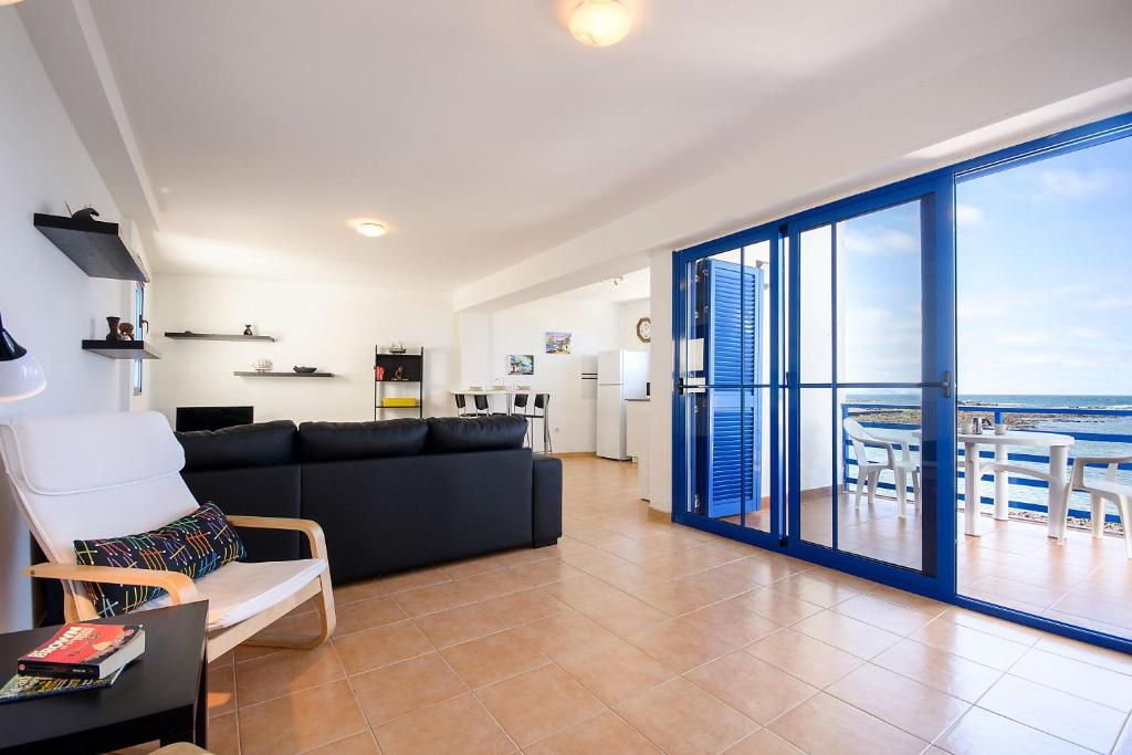 a living room with a couch and a view of the ocean at Mirador del Roque in Órzola