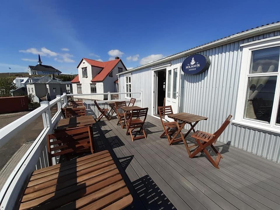 a deck with chairs and tables on a building at Gistihús Hólmavíkur in Hólmavík