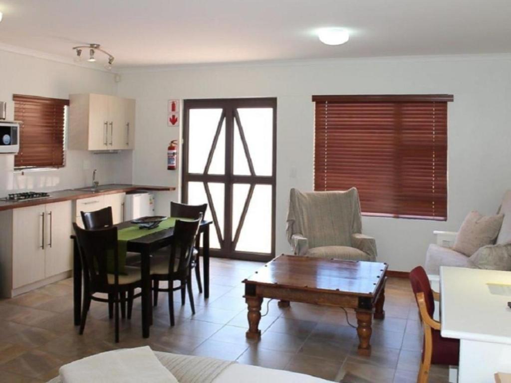 a kitchen and living room with a table and chairs at 12 on Beach Guest House in Saldanha