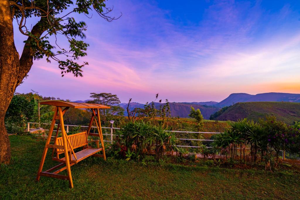
a wooden bench sitting in the middle of a grassy field at Winter Vale Green Stay Resorts in Vagamon
