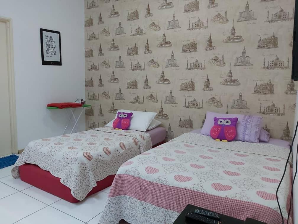 a bedroom with two beds with hello kitty pillows at Vista Alam Roomstay Homestay in Shah Alam