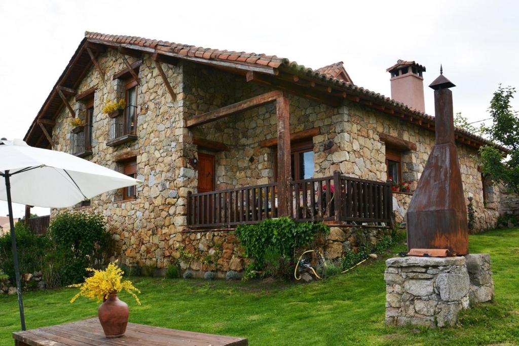 uma casa de pedra com uma estátua em frente em Casa del Altozano em Barajas de Gredos