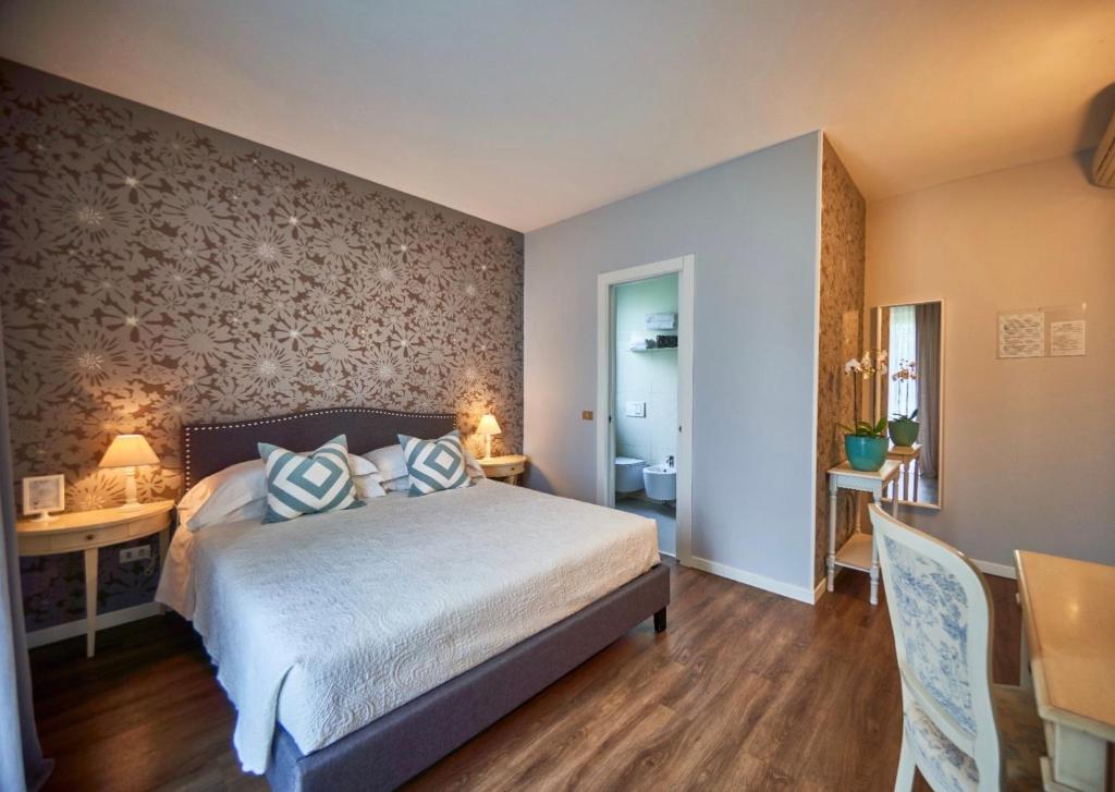 a bedroom with a bed and a dining room at Hotel Clodia - Adults Only in Sirmione
